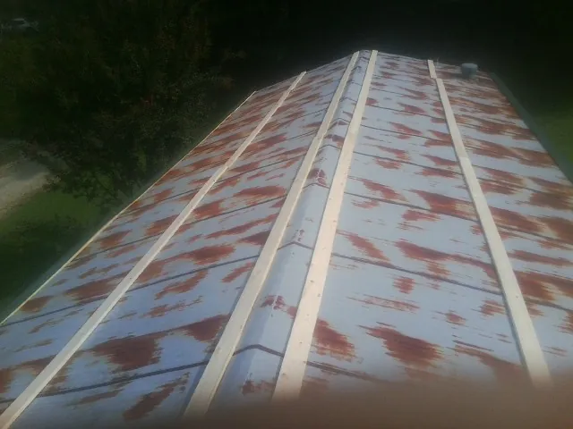 Rusted metal roof panels with new wood purlins before replacement — Storm Damage Roof Repair in Afton by Roofing Brothers